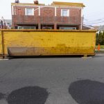 Old,Long,Yellow,Dumpster,On,An,Asphalt,Street,In,Front