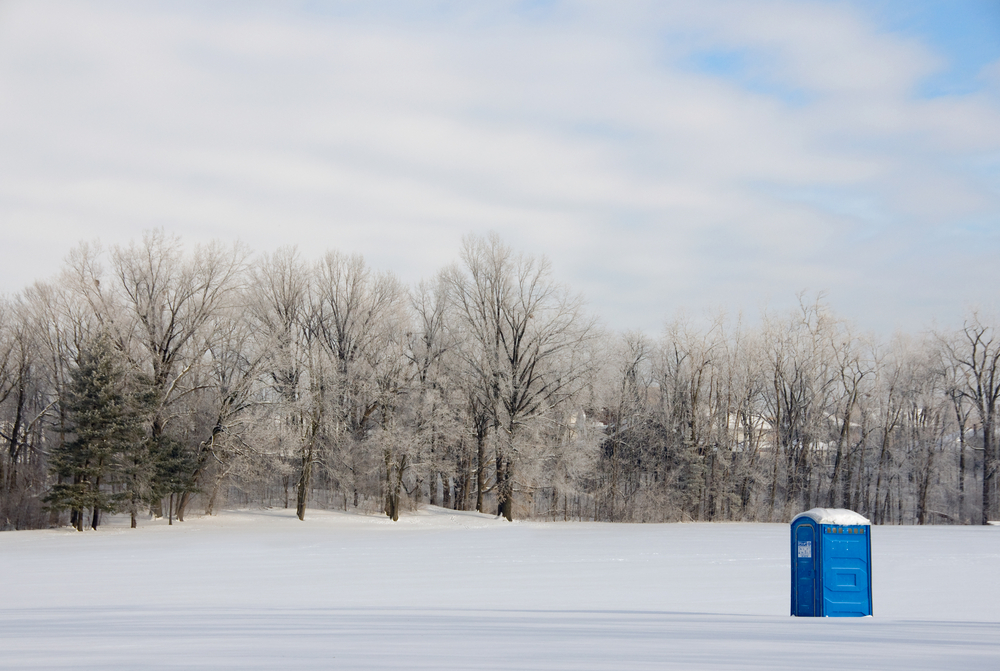 A,Port-a-potty,Sits,In,A,Remote,Field,Covered,In,Snow